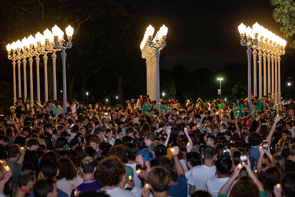 Students raising their hands to an illuminated Light of Reason